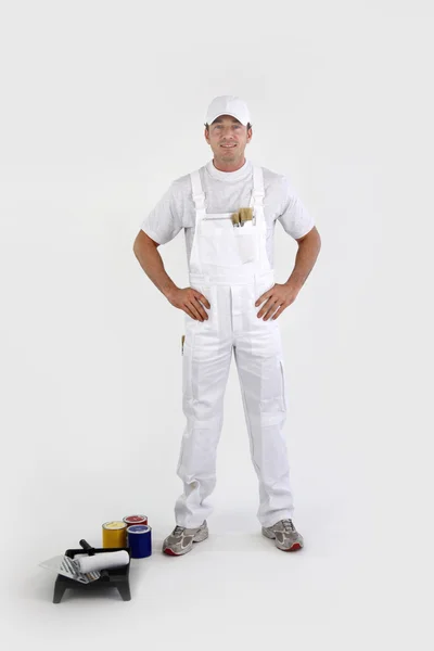 Decorator with a roller and cans of primary colored paint — Stock Photo, Image