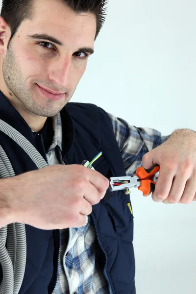Eletricista cortando um cabo — Fotografia de Stock