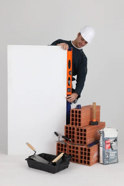 Construtor com uma placa deixada em branco para sua mensagem — Fotografia de Stock