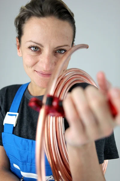 Fontanero femenino cortando tubería de cobre — Foto de Stock