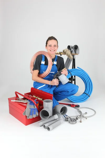 Female plumber crouching by equipment — Stock Photo, Image