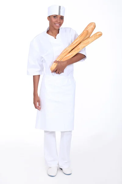 Female baker with loaves of bread — Stock Photo, Image