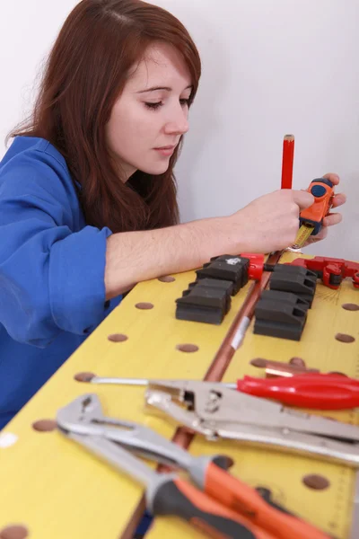Female plumber cutting copper pipe — Stock Photo, Image