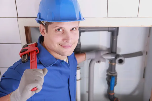 Knappe jonge loodgieter met een moersleutel — Stockfoto