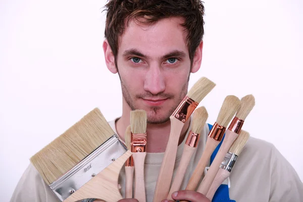 Painter holding variety of brushes — Stock Photo, Image