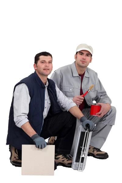 Tile cutter and painter kneeling together — Stock Photo, Image
