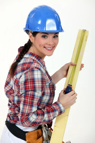 Operaio edile che misura un pezzo di legno — Foto Stock
