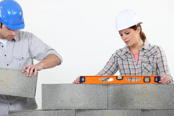 Homem e mulher pedreiros empilhamento de tijolos — Fotografia de Stock