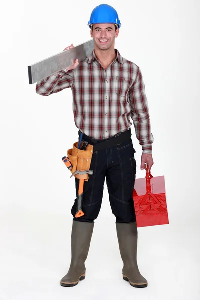 Trabajador que lleva una plancha de aluminio y una caja de herramientas —  Fotos de Stock