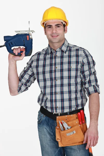 Řemeslník drží vrtačku — Stock fotografie