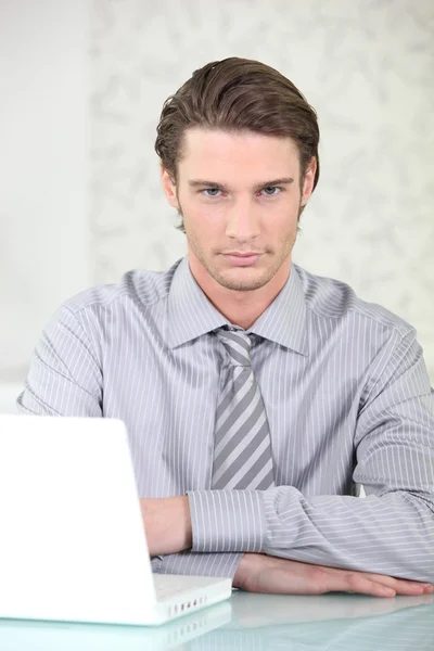 Uomo che indossa camicia e cravatta seduto con computer portatile — Foto Stock