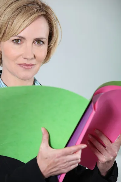 Woman holding brightly colored files — Stock Photo, Image