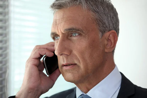 Mature businessman talking on his cell — Stock Photo, Image