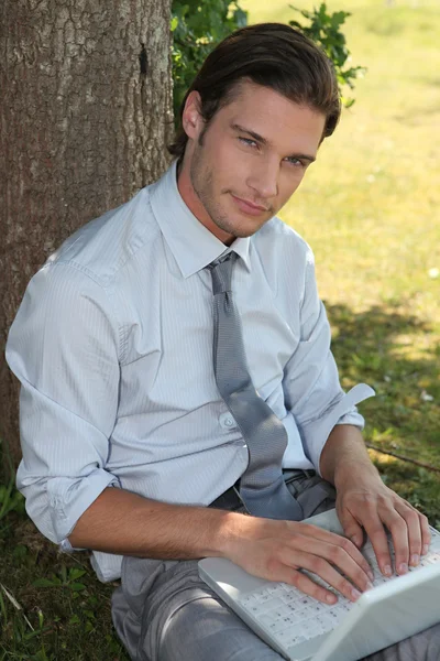 Young man in suit relaxing in a park — Stock Photo, Image