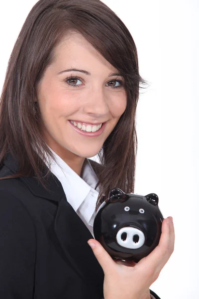 Jonge vrouw die lacht met een piggy bank — Stockfoto