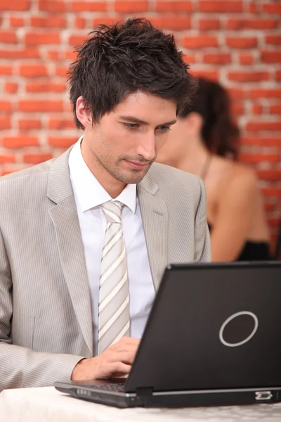 Άνθρωπος που εργάζονται σε ένα φορητό υπολογιστή σε ένα εστιατόριο — Φωτογραφία Αρχείου