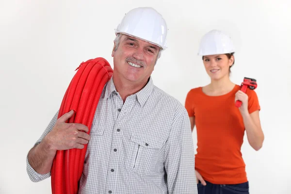Experienced tradesman with his assistant in the background — Stock Photo, Image
