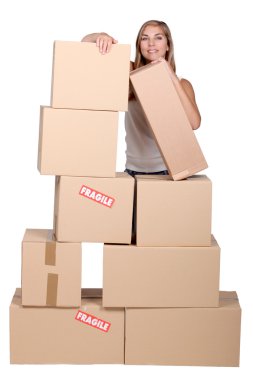 Young woman with a pile of cardboard boxes marked fragile clipart