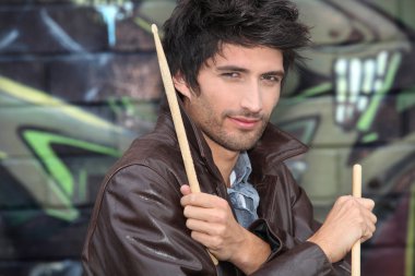 Drummer standing in front of graffiti clipart