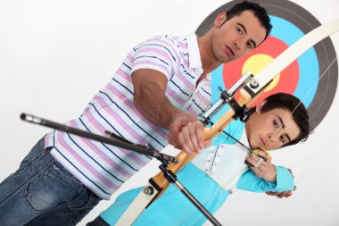 Brothers practising archery clipart