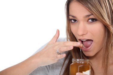 Woman dipping finger into jam clipart