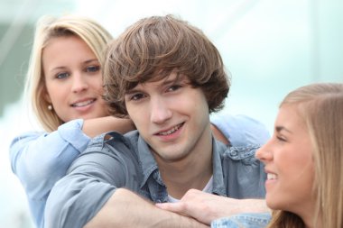 Three smiling teenagers sitting together clipart