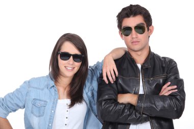 Young couple posing in sunglasses and leather jacket clipart