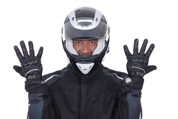 Motocyklista na sobie czarny płaszcz, rękawice i kask — Zdjęcie stockowe