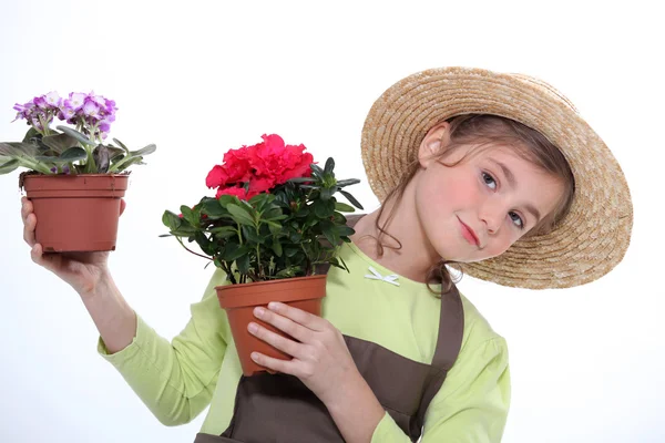 9 anos de idade menina vestida de horticultor levando vasos de flores — Fotografia de Stock
