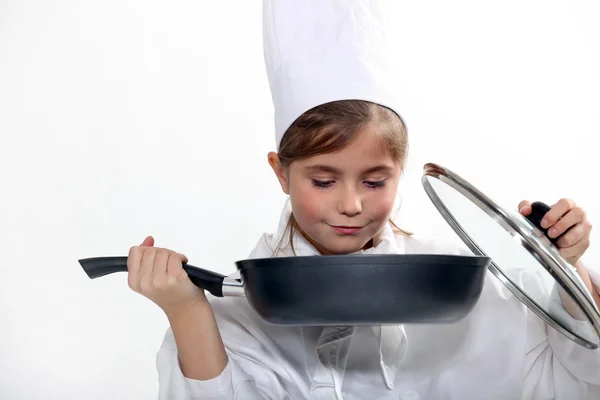 Küçük kız beyaz zemin üzerinde bir aşçı gibi giyinmiş. — Stok fotoğraf
