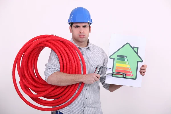 Grumpy man giving a property an energy efficiency rating of G — Stock Photo, Image