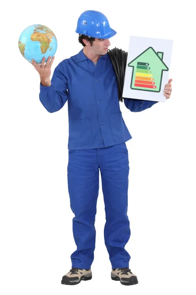 Man stood with globe and energy efficiency logo — Stock Photo, Image