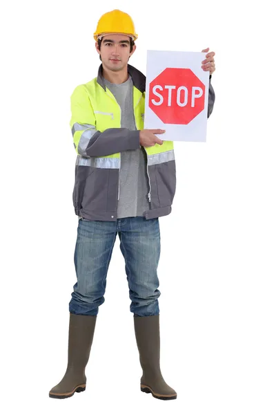 一个拿着停车标志的道路工人. — 图库照片