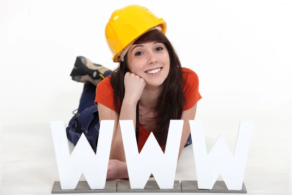 Junge Handwerkerin posiert hinter einem WWW-Symbol — Stockfoto