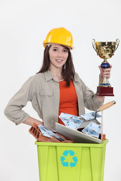 Female laborer holding gold cup — Stock Photo, Image