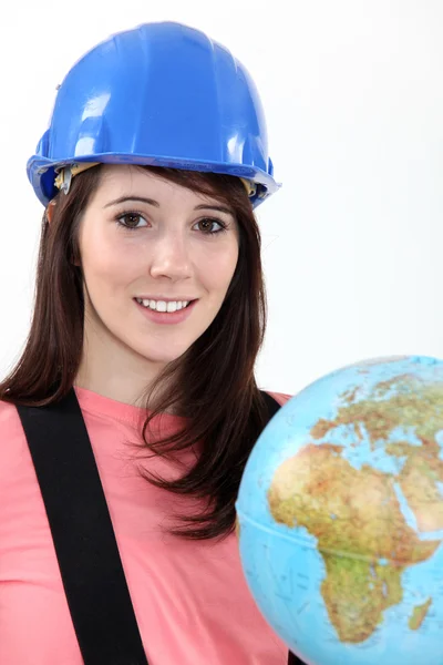 Mladá žena v bezpečnostní přilba s obrázkem zeměkoule — Stock fotografie