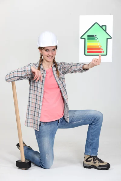 Tradeswoman holding up an energy efficiency rating chart — Stock Photo, Image