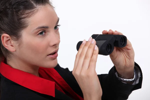 Mujer sospechosa mirando a través de prismáticos —  Fotos de Stock