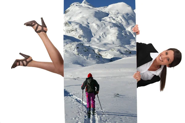 Businesswoman holding a ski vacation poster — Stock Photo, Image