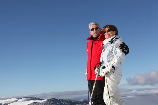 Äldre par njuter vistelse på ski — Stockfoto