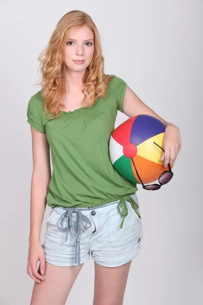 Mladá žena držící míč beach — Stock fotografie