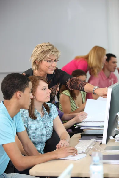 Profesora ayudando a sus estudiantes —  Fotos de Stock