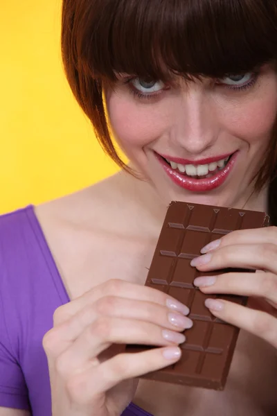 Piękna młoda kobieta jedzenie czekolady — Zdjęcie stockowe
