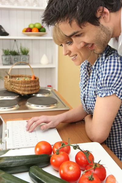 Pareja joven cocinando con internet — Foto de Stock