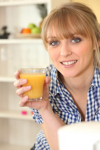 Жінка п'є склянку апельсинового соку — стокове фото