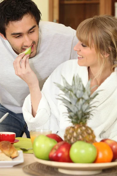Νεαρό ζευγάρι να τρώνε φρούτα στο πρωινό — Φωτογραφία Αρχείου