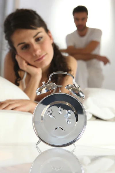 Casal olhando para um despertador — Fotografia de Stock