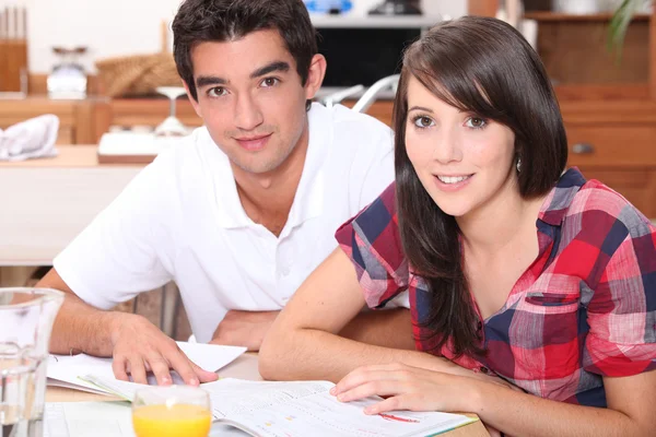 Couple reading in kitchen — Stock Photo, Image