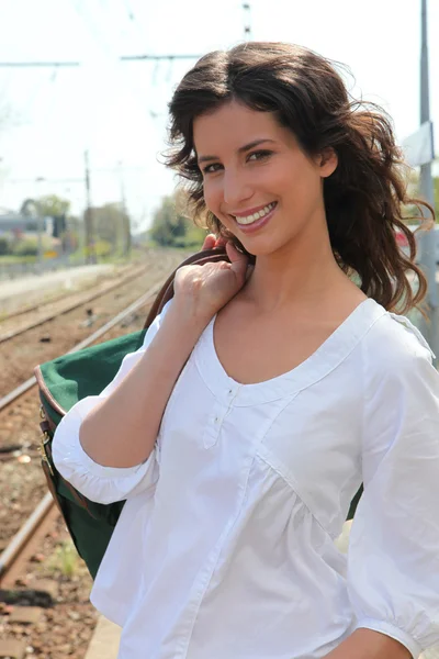 Mujer joven sonriendo con bolsa de viaje —  Fotos de Stock