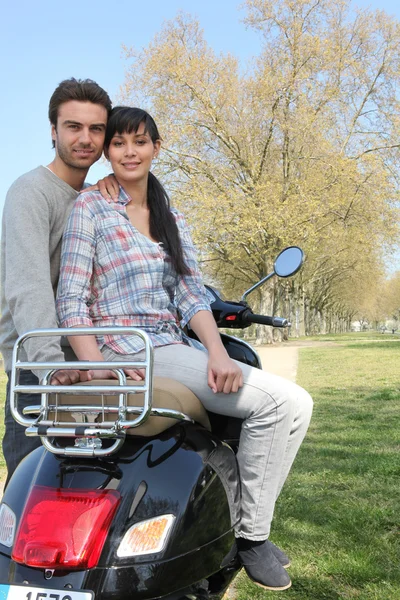 Casal no parque com sua scooter — Fotografia de Stock